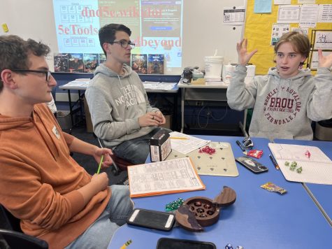 Dungeon Master Gray Garska (right) gives a vivid character description. Joe Ozanich (far left) and Evan Lupher (mid-left) listen intently.