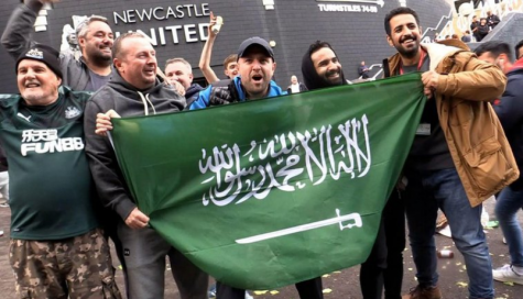 Newcastle United fans celebrate the clubs Saudi takeover by waving a Saudi flag outside St James Park.