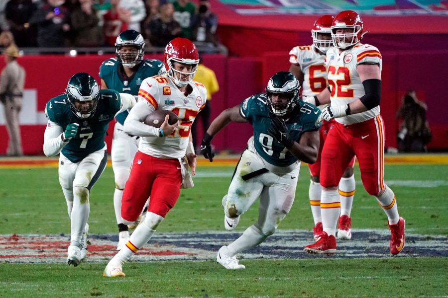 Chiefs quarterback Patrick Mahomes scrambles with Eagles linebacker Haason Reddick and defensive tackle Javon Hargrave giving chase.