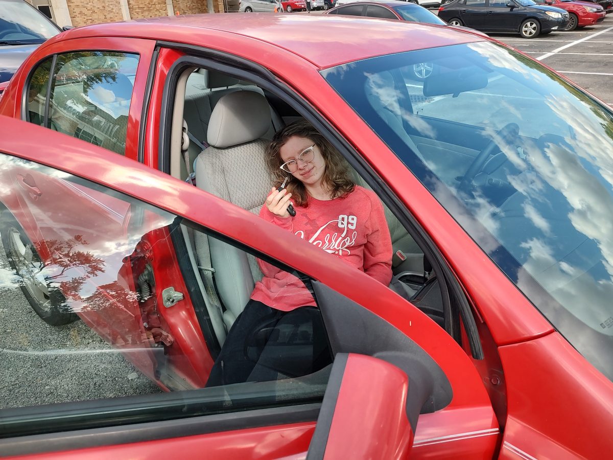 Senior Alana Pickering holds up her keys while sitting in her Chevy Cobalt
