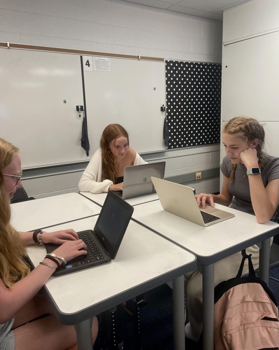 Juniors Alex Sims and Ellie Anspach and Sophomore Sophia Ball Working at a Tall Whiteboard Desk