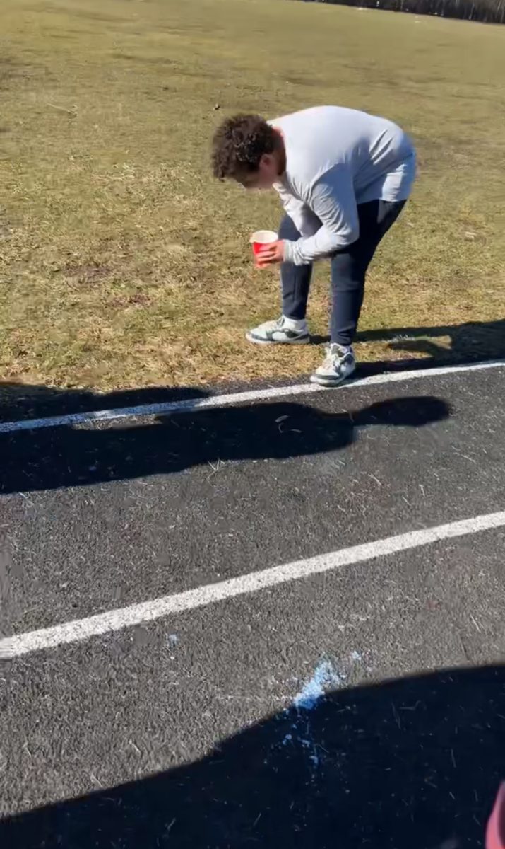 Noah Katkowsky in action of drinking milk while participating in the last place punishment: The milk mile. 