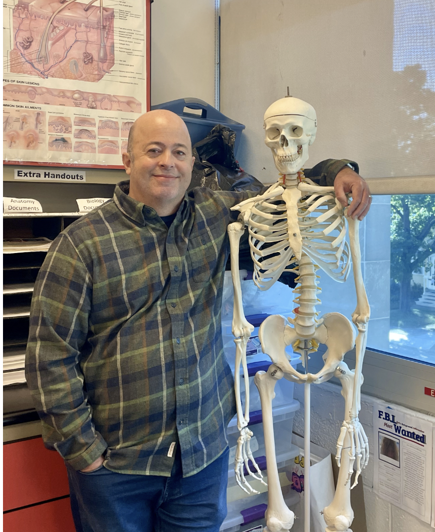 Mr. Skowronski poses for a picture next to a class skeleton.