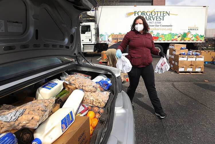 Volunteers pack cars full of food before distribution.