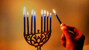 Lighting the candles of a menorah