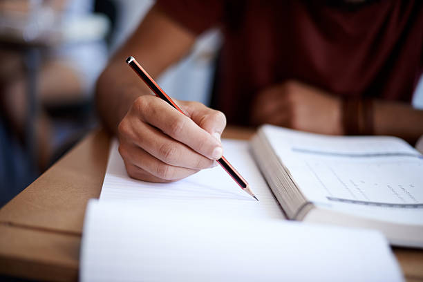 Closeup shot of a student writing on a note pad