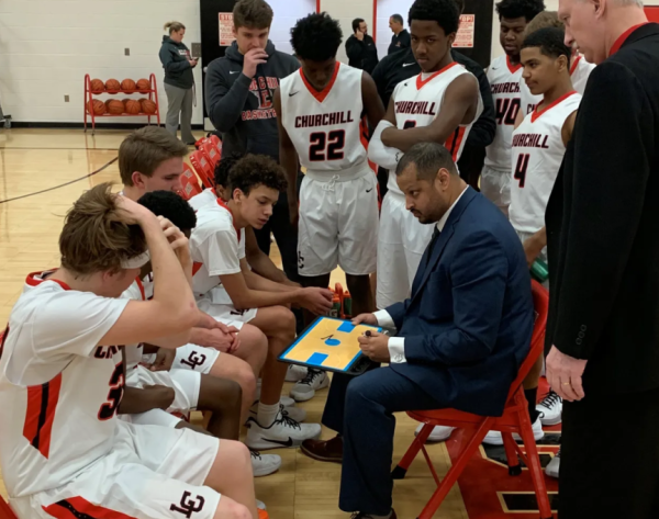 Coach McCulloh in the huddle with Livonia Churchill. Photograph by Andrew Vailliencourt.