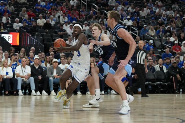 Nov 3, 2025; Las Vegas, Nevada, USA; BYU Cougars forward AJ Dybantsa (3) drives past Villanova Wildcats forward Matt Hodge (33) and forward Duke Brennan (24) during the first half of the Hall of Fame Series game at T-Mobile Arena.  Candice Ward-Imagn Images