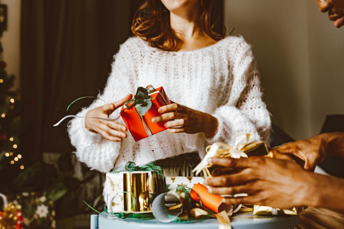 Women opening gift during holidays. (Photo by ROMAN ODINTSOV) 