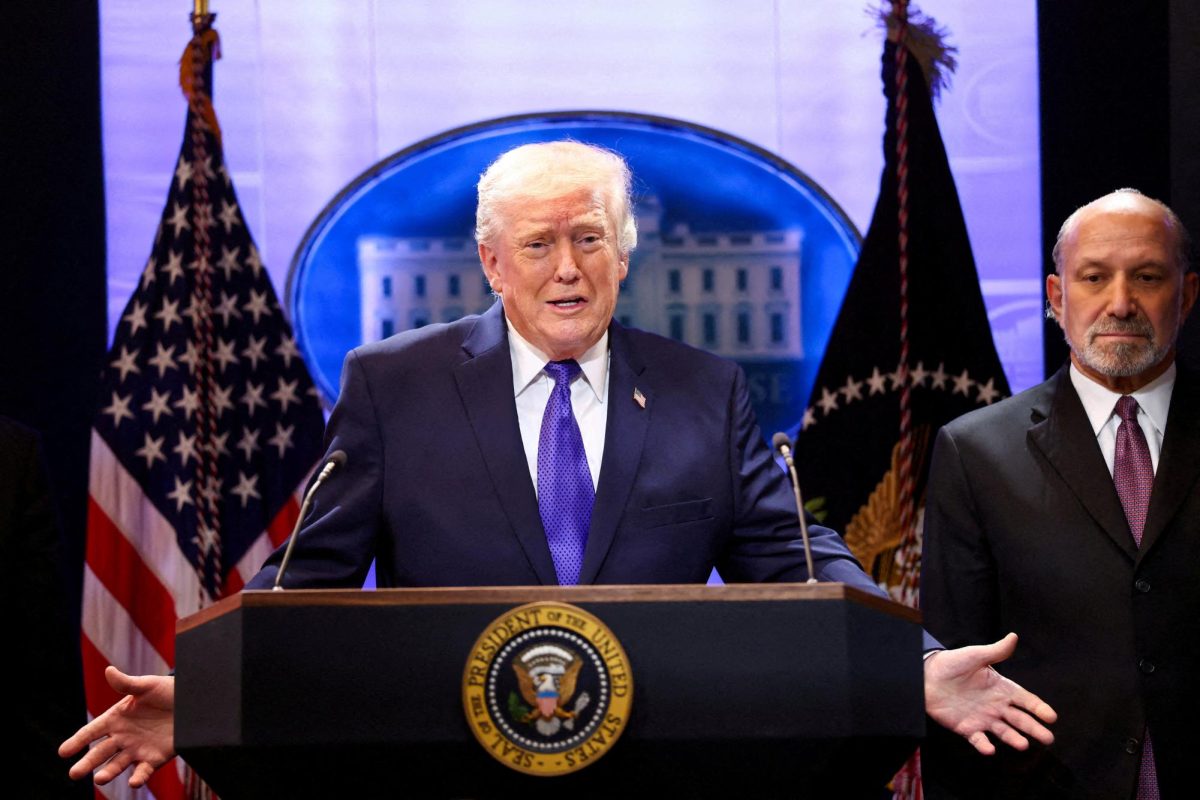 U.S. President Donald Trump, flanked by Secretary of Commerce Howard Lutnick speaks during a press briefing at the White House, following the Supreme Court's ruling that Trump had exceeded his authority when he imposed tariffs, in Washington, D.C., U.S., February 20, 2026. REUTERS/Kevin Lamarque