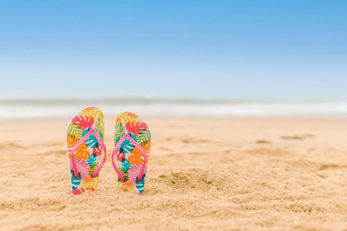 A beach scene with a pair of flip flops 
(Photo from Pexels)